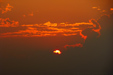 A plane heading for landing at JFK above the setting sun in NYC
